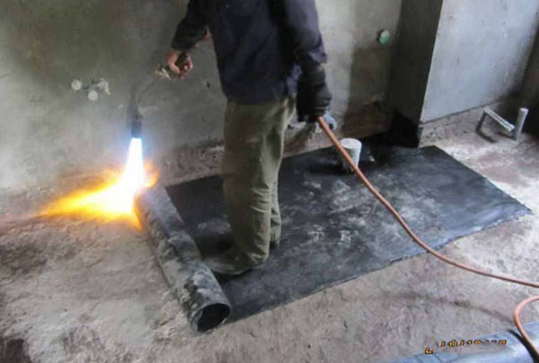 Dùng đèn khò đốt nóng mặt bitum của màng chống thấm